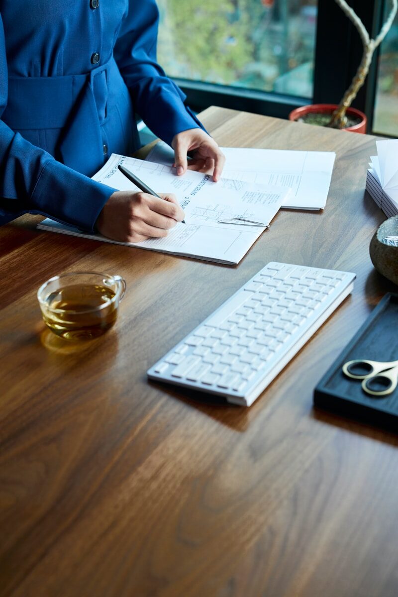 a woman sitting at a desk with a keyboard and papers